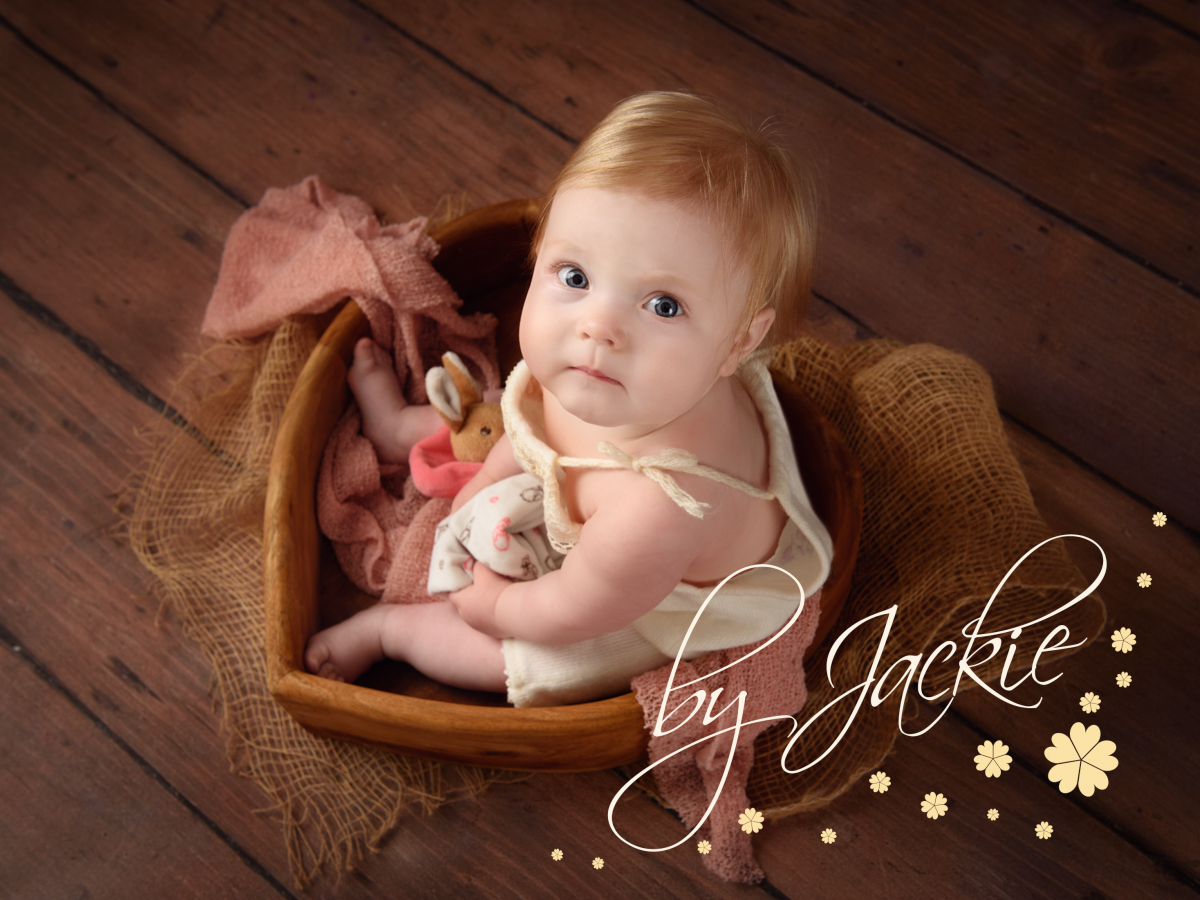 Image of 8 month old baby girl sitting in heart bowl by Babies By Jackie Photography, specialist baby and child photographer in York, Leeds, Harrogate