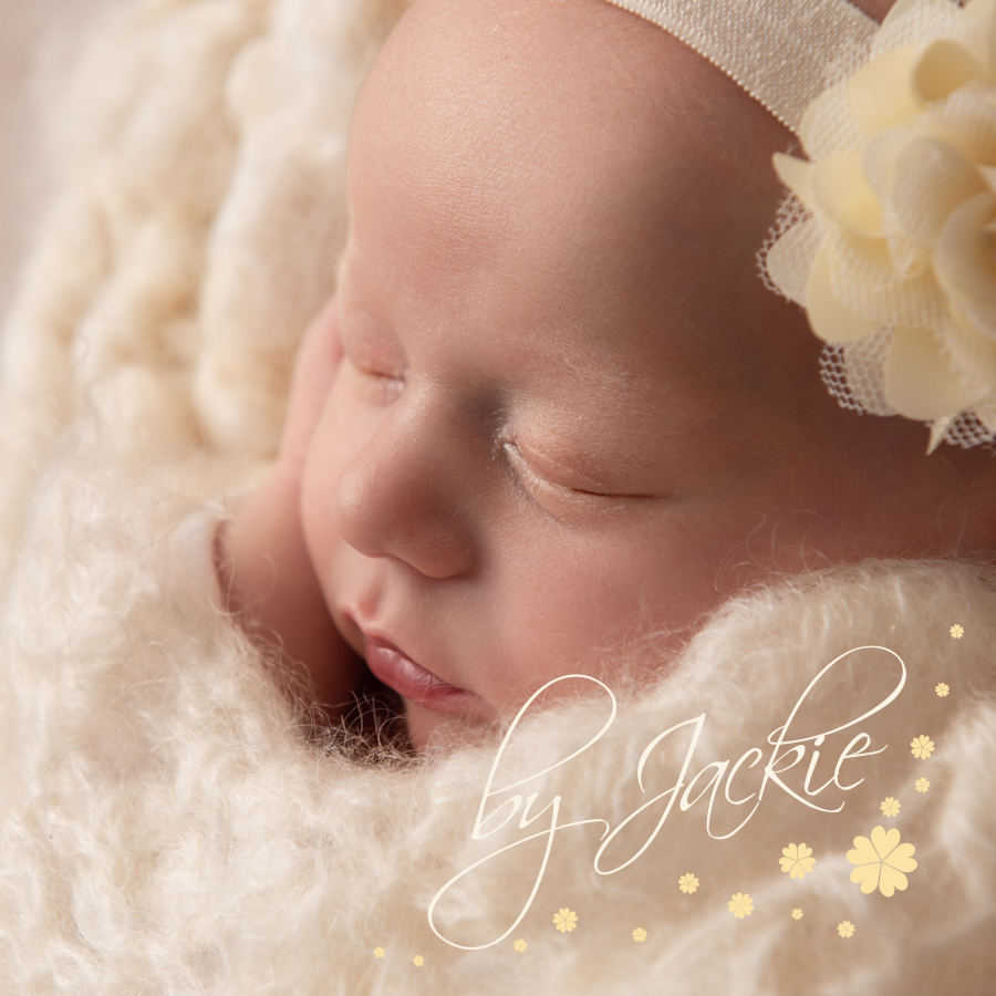Baby girl snuggled in cream blanket