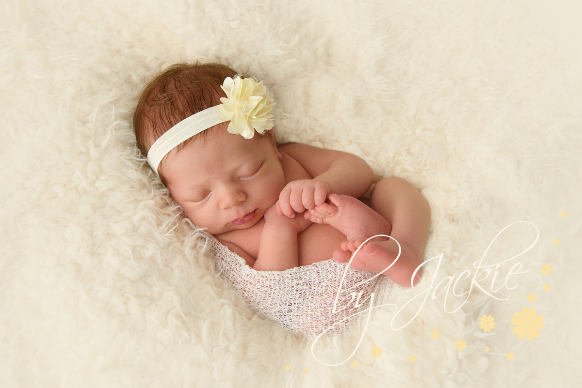 Baby girl asleep in soft cream blanket by Babies By Jackie Photography, specialist baby photographer in York, Leeds, Harrogate