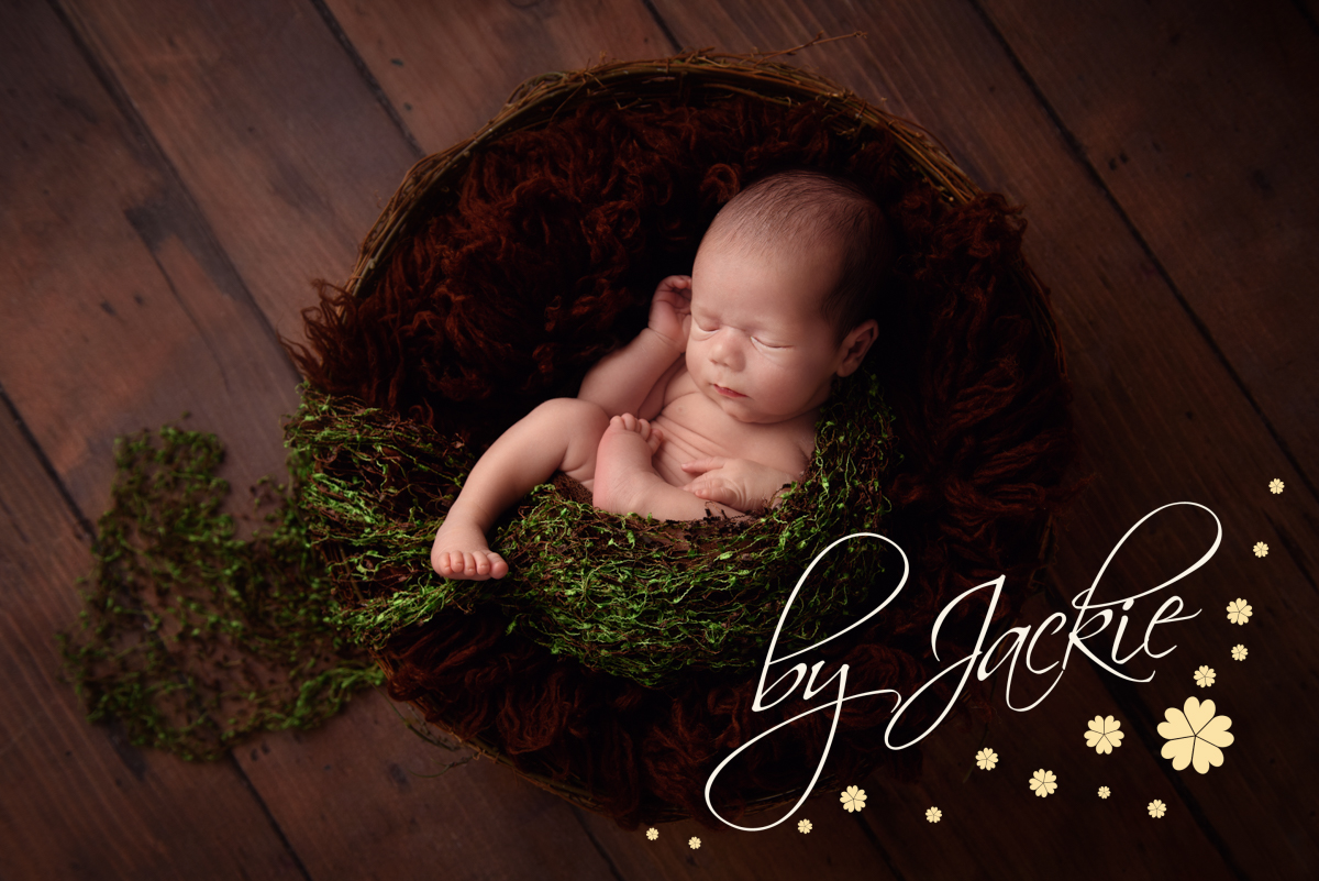 Image of newborn baby boy nestled in asleep by Babies By Jackie Photography, specialist baby photographer in York, Leeds, Harrogate