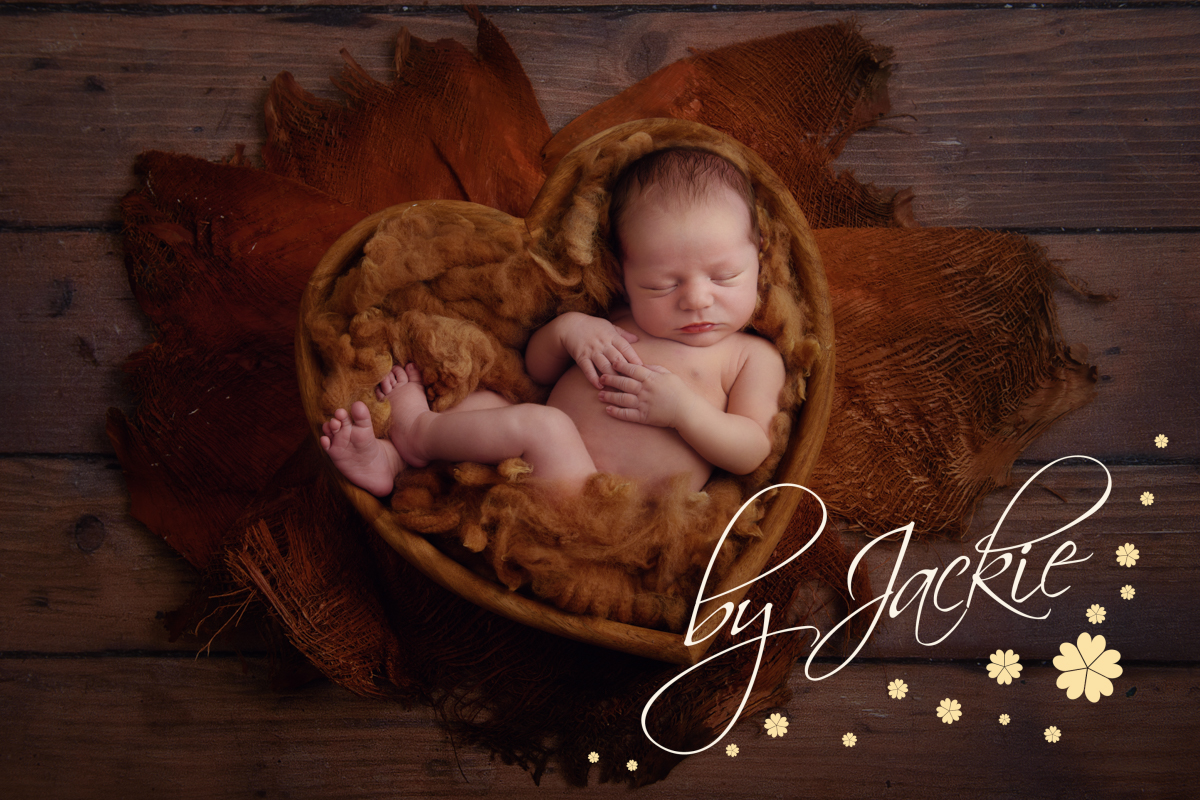 Newborn baby boy asleep in heart bowl by Babies By Jackie Photography, specialist baby photographer in York, Leeds, Harrogate