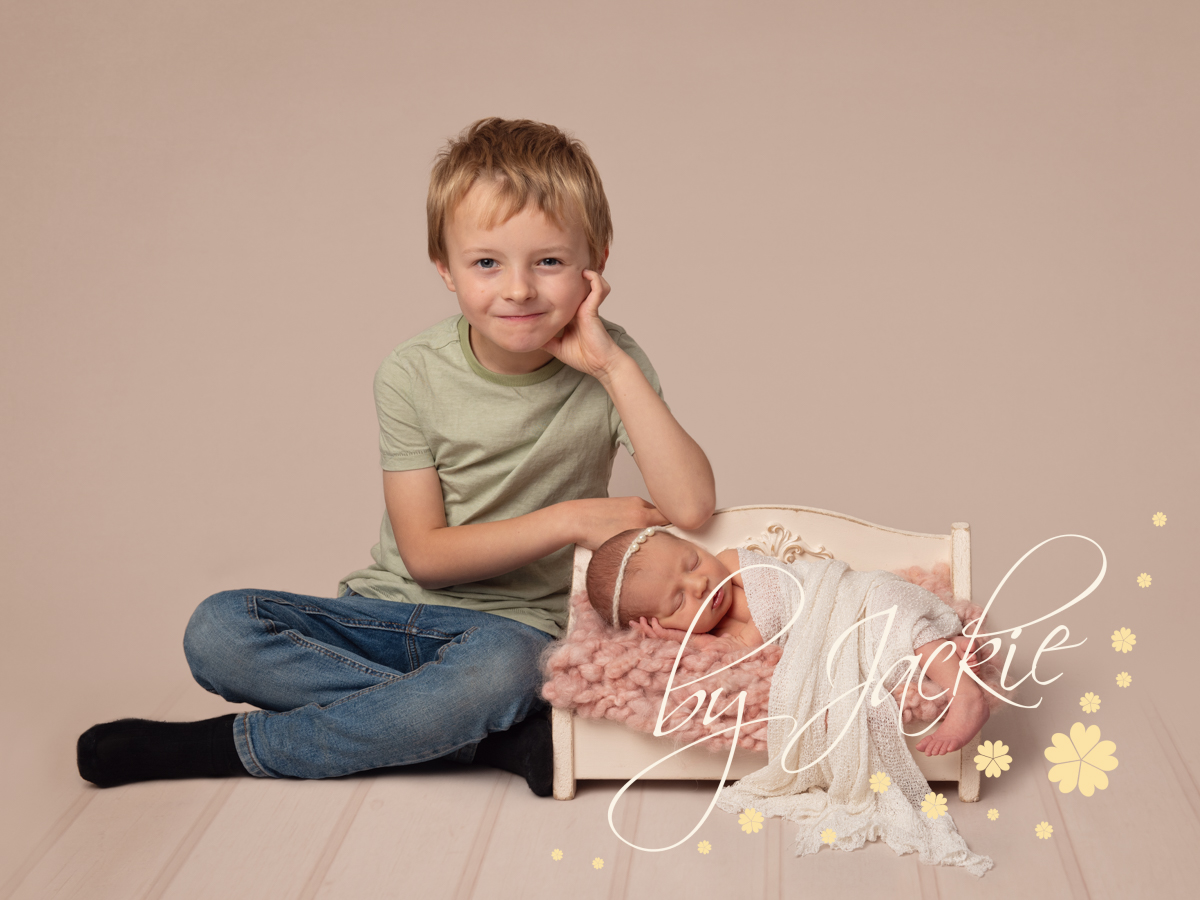 Newborn baby with older brother portrait. Copyright Babies by Jackie