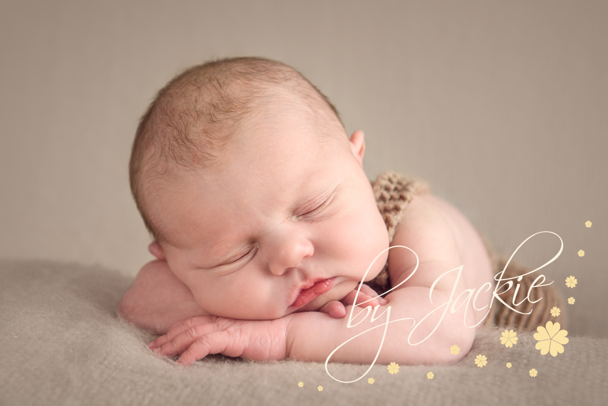 Newborn baby boy asleep on light brown blanket by Babies By Jackie Photography, specialist baby photographer in York, Leeds, Harrogate
