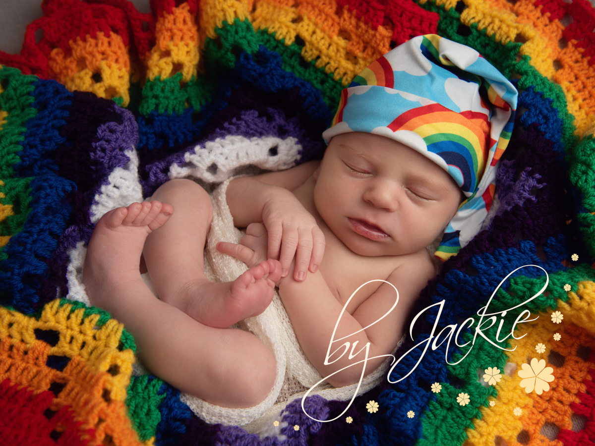 Newborn baby portrait with rainbow blanket. Copyright Babies by Jackie