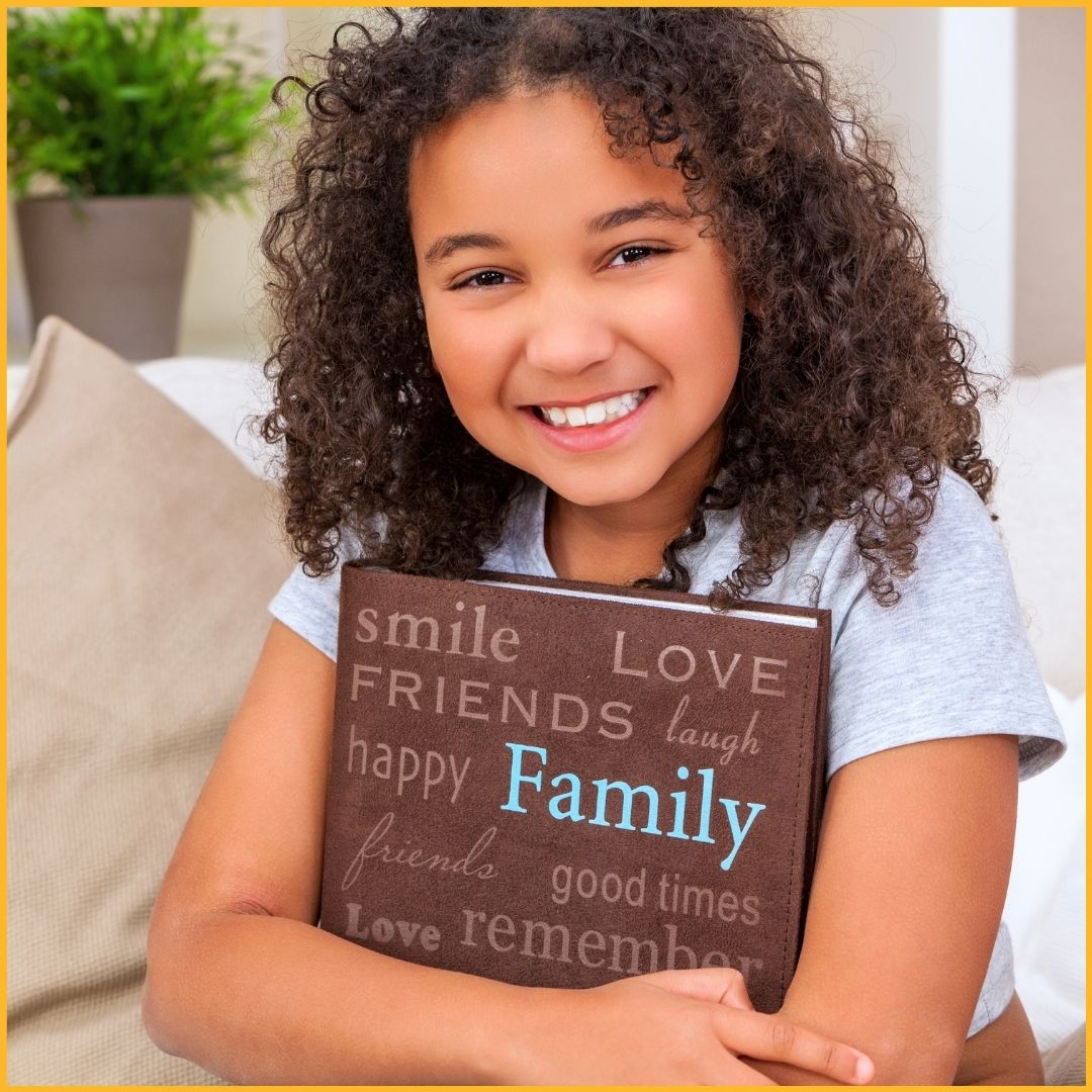 child holding photo album and feeling happy and loved