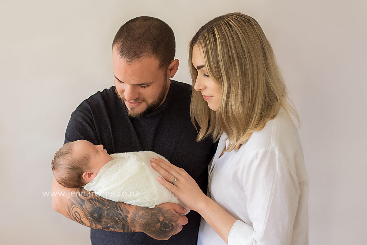 mother and father holding newborn baby
