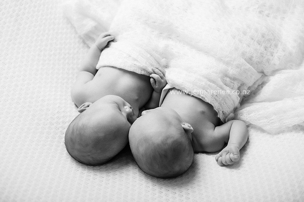 Newborn baby sleeping curled up on tummy