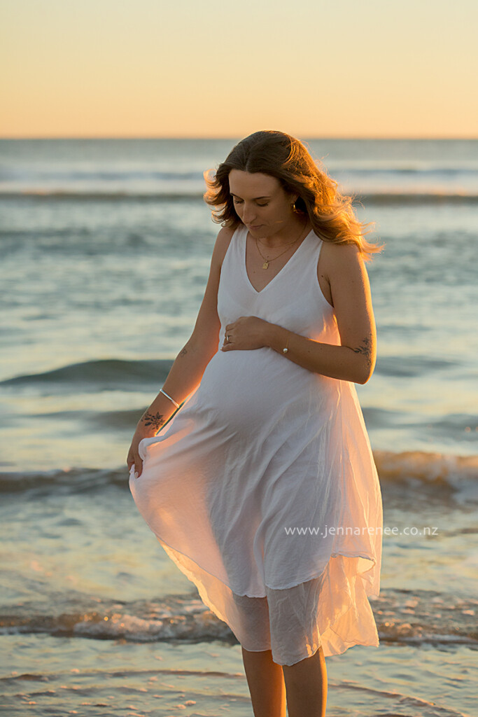 pregnant woman in flowy dress at mount maunganui beach